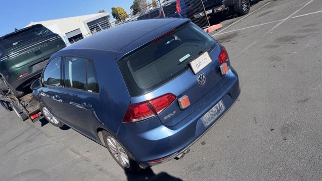 Blue Volkswagen Golf hatchback secured on a tow truck